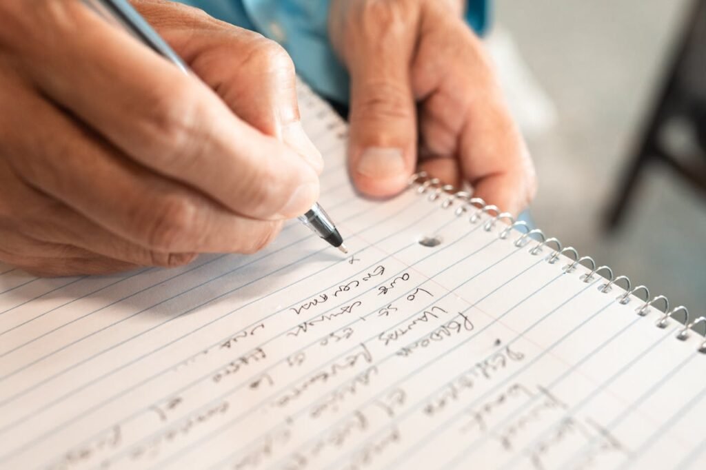 Detailed image of hands writing in a notebook, emphasizing creativity and organization.